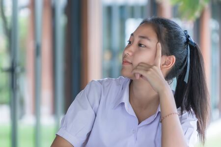 Young Asian college students in uniform beautiful girl relax and smile at coffee shop for learning online, Casual business, social meeting, or education concept.の写真素材