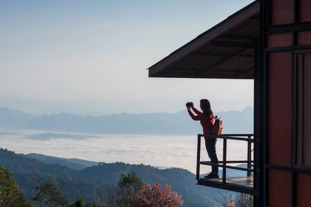 Female tourists are recording beautiful scenery in the morning with a sea of mist at Doi mae taman san pa kia chiang mai thailand.の写真素材