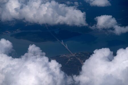 Beautiful aerial view above clouds, Airplane view with bridge.の写真素材