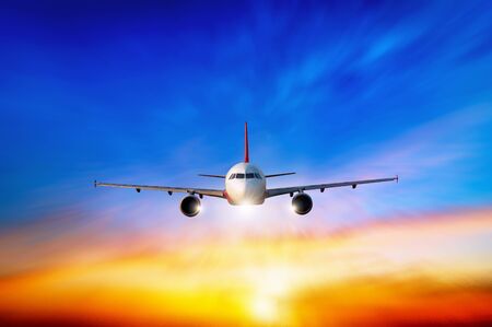 Commercial airplane flying above clouds in dramatic sunset light.  Fast Travel and transportation concept, Passenger airplane Travel.の写真素材