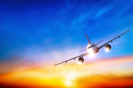 Commercial airplane flying above clouds in dramatic sunset light.  Fast Travel and transportation concept, Passenger airplane Travel.の写真素材