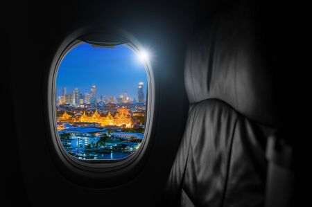 Airplane interior with window view of Grand Palace is actually a collection of structures in Rattanakosin, the historic center of Bangkok, Thailand, Concept of travel and air transportation.の写真素材