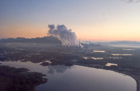 Aerial view steam fumes above the coal power plant in large area The machine is working to generate electricity the morning with fog and clouds.の写真素材