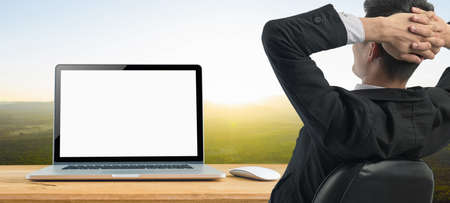 Mockup image of Businessman relax sitting on chair with Blank laptop and mouse on desk, Blank white space on the screen, mockup template.の写真素材