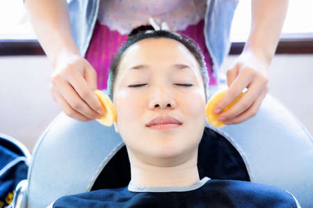 Asian girl beautiful skin is sleeping for the staff to use the puff to gently clean the face.の写真素材