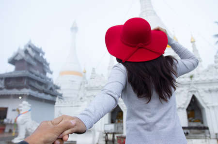 A young tourist wearing a red hat Visit Wat Phra That Doi Kong Mu on a foggy day, Mae Hong Son Province, Thailand.の写真素材