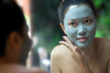 Beautiful asian woman Facial mask with natural mud to nourish the skin for beauty. Phu Klon, Mae Hong Son Province, Thailand.の写真素材
