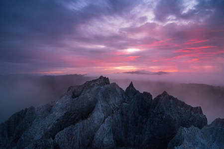 Beautiful morning sunrise over the sea of fog on rocky mountains.の写真素材