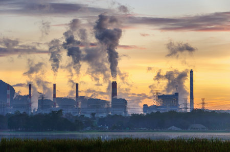 Coal power plant and steam from the flue in the beautiful morning among the mountains and lakes. Mae Moh, Lampang, Thailand. Lines a row high voltage pole.の写真素材