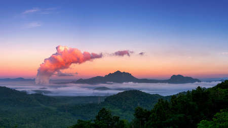Beautiful sea of fog in the mountains, high voltage pole and steam from the coal power plant in the morning sunrise . Mae moh, Lampang, Thailand. Energy and environment concept .の写真素材