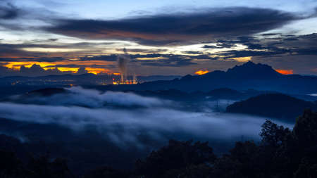 Aerial view beautiful mist after the rain on the mountain high voltage pole and steam from a coal power plant at sunset, Pang Puey, Mae Moh, Lampang, Thailand. Long exposure. Panorama.の写真素材