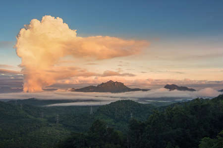 Beautiful sea of fog in the mountains, high voltage pole and steam from the coal power plant in the morning sunrise . Mae moh, Lampang, Thailand. Energy and environment concept .の写真素材