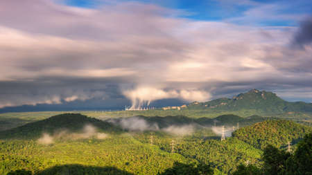 Beautiful sea of fog in the mountains, high voltage pole and steam from the coal power plant in the morning sunrise . Mae moh, Lampang, Thailand. Energy and environment concept .の写真素材