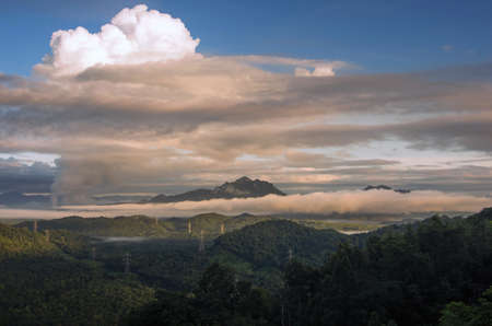 Beautiful sea of fog in the mountains, high voltage pole and steam from the coal power plant in the morning sunrise . Mae moh, Lampang, Thailand. Energy and environment concept .の写真素材