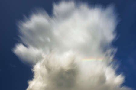 long exposure clouds with rainbow clear skyの写真素材