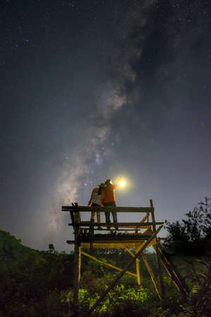 Milky Way in the night sky and a couple watching the beauty of the Milky Way galaxy.の写真素材