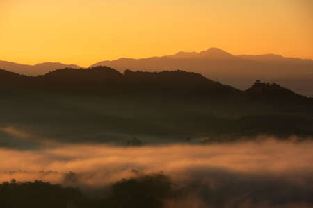 Beautiful fog and golden light in the morning forest with green mountains. Baan Jabo, Mae Hong Son, Thailand.の写真素材