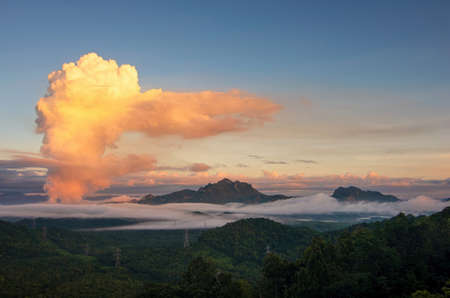 Beautiful sea of fog in the mountains, high voltage pole and steam from the coal power plant in the morning sunrise . Mae moh, Lampang, Thailand. Energy and environment concept .の写真素材
