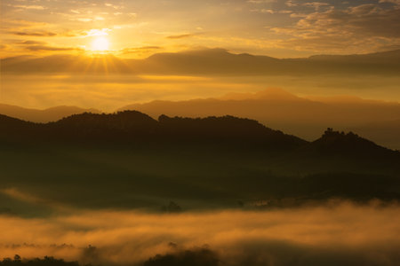 Beautiful fog and golden light in the morning forest with green mountains. Baan Jabo, Mae Hong Son, Thailand.の写真素材