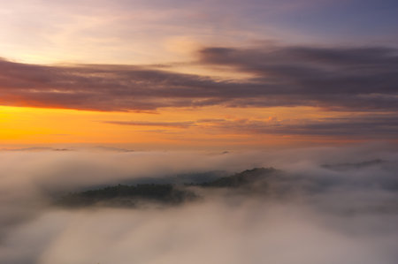 Aerial view Beautiful morning scenery Golden light sunrise And the mist flows on high mountains forest. Pang Puai, Mae Moh, Lampang, Thailand.の写真素材
