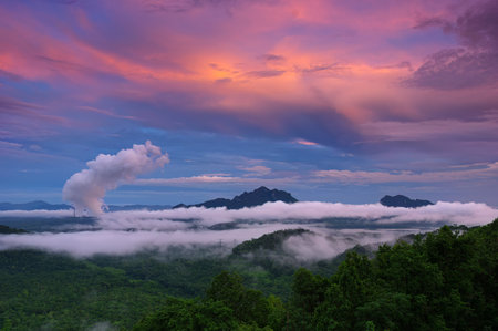 Beautiful sea of fog in the mountains, high voltage pole and steam from the coal power plant in the morning sunrise . Mae moh, Lampang, Thailand. Energy and environment concept .の写真素材