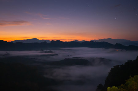 Aerial view Beautiful morning view of sunrise, golden light and mist flowing on the highland fields, Ban Cha Bo, Mae Hong Son,Thailand.の写真素材