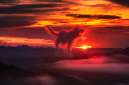 Fox-shaped smoke from the chimney of the coal-fired power plant The evening sun had fog in the foreground, warm light.の写真素材