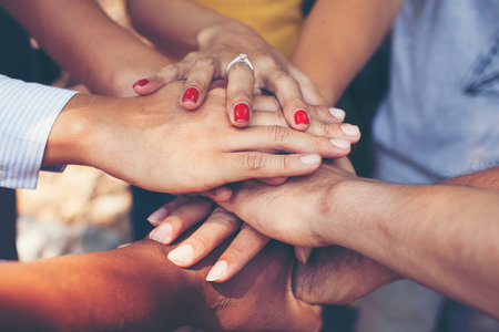 Concept of teamwork: Close-Up of hands business team showing unity with putting their hands...