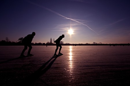 Ice skating at sunset in the Netherlandsの写真素材