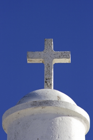 White cross on a chapel against a blue sky in Portugalの写真素材
