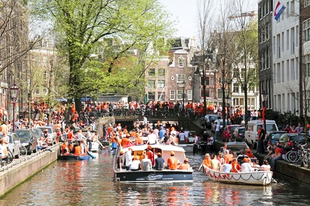 AMSTERDAM - APRIL 30: Amsterdam canals full of boats and people in orange during the celebration of queensday on April 30, 2012 in Amsterdam, The Netherlandsのeditorial素材