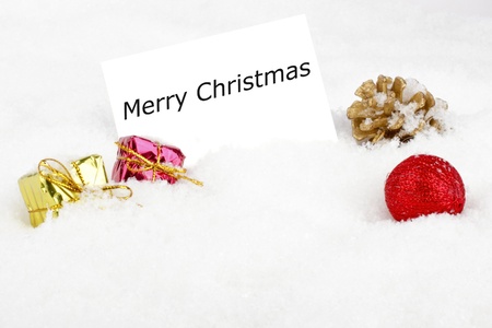 Blank white card with christmas decoration in the snowの写真素材