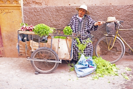 MARRAKECH, MOROCCO - OCTOBER 22 Maroccan man selling vegetables at the market at Marrakech, Morocco on 22th october 2013のeditorial素材