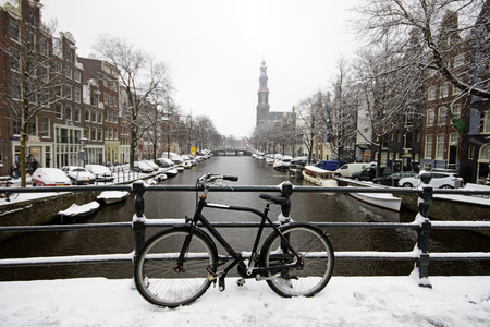 Amsterdam covered with snow with the Westerkerk in winter in the Netherlandsの写真素材