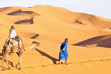 Camel caravan going through the sand dunes in the Sahara Desert, Morocco.のeditorial素材