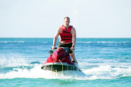 Young guy cruising on a jet ski on the caribbic sea