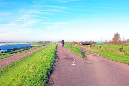 Biking on the dyke near Amsterdam in the Netherlandsの写真素材