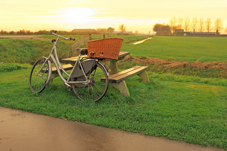 Bike against a picnic bench in the countryside from the Netherlands at twilightの写真素材