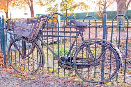 Old fashioned dutch bike against a fence in Netherlandsの写真素材