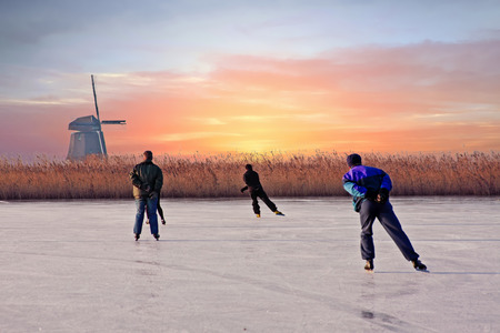 Ice skating in the countryside from the Netherlands at sunsetの写真素材