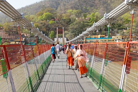 INDIA, LAXMAN JHULA - APRIL 8, 2017: People walking on the suspension bridge in Laxman Jhula on the 8th of april 2017のeditorial素材