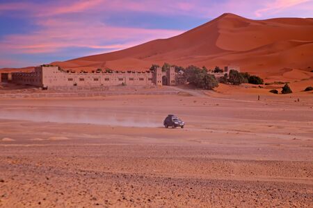Driving through the Sahara Desert in Morocco Africa at sunsetの写真素材