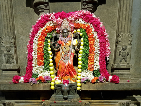 Ancient Durga statue decorated with flowers in the Sri Ramana Ashram in Tiruvanamalai Indiaのeditorial素材