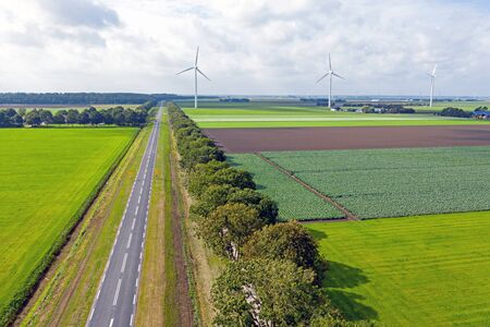 Aerial from a typical dutch landscape: straight roads, windmills and beautiful meadows in the Netherlandsの写真素材