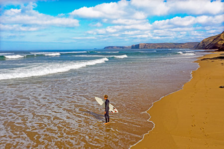 Aerial from a young surfer ready to surf at the atlantic ocean