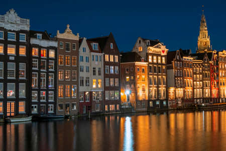 Amsterdam houses along the Damrak in the Netherlands at nightのeditorial素材