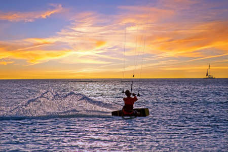 Kite surfing at Palm Beach on Aruba island in the Caribbean Sea at sunsetの写真素材