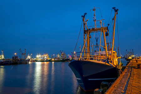 Fishing boats in the harbor from Lauwersoog in the Netherlands at night