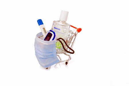 Desinfentant gel, thermometer, blood saturation meter and a medical mask in a shopping cart, concept