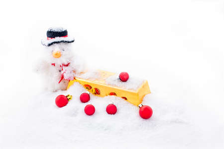 Christmas man with a gold bar and red christmas balls in the snowの写真素材
